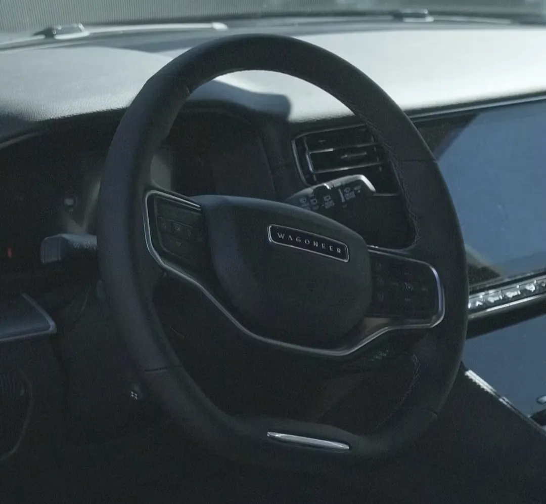 Image of the right side of a white SUV car being sprayed with a foam cleaning solution.